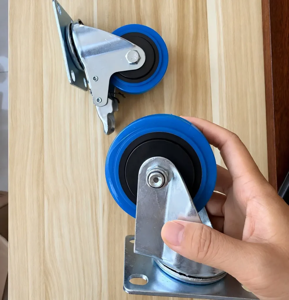 Blue TPR swivel plate caster held to show the wheel hub and mounting bracket
